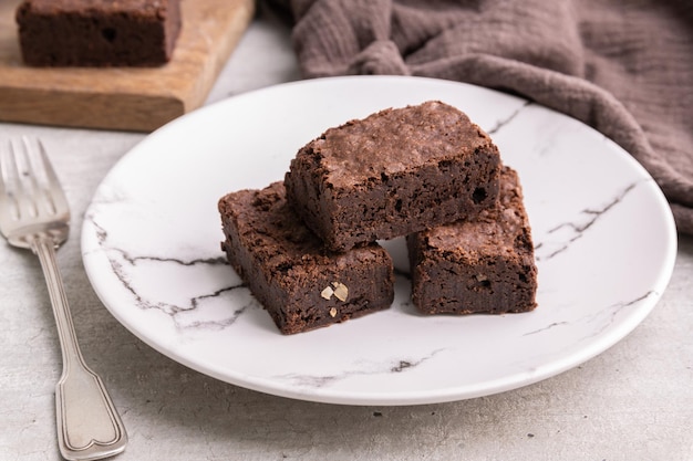 Brownies su un piatto sopra la tavola di legno bianca