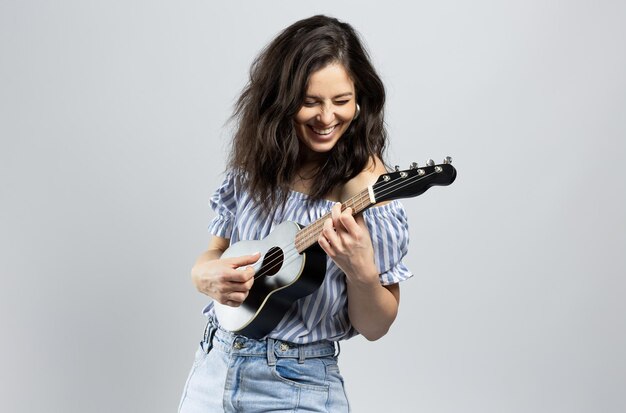 Bruna carina che suona l'ukulele