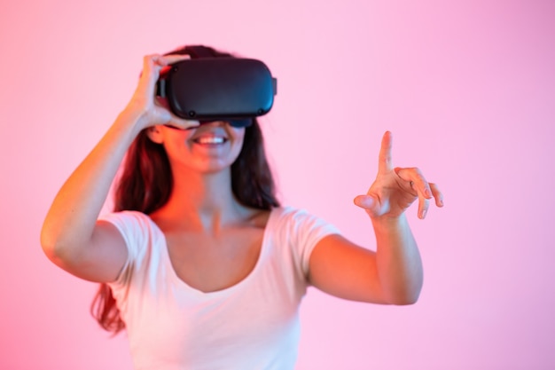 Bruna con auricolare che punta il dito nella realtà virtuale