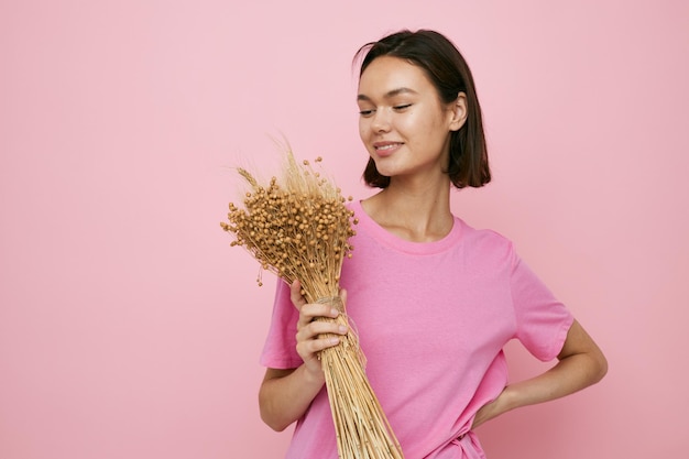 Bruna dai capelli corti un bouquet di fiori secchi maglietta rosa Stile di vita inalterato