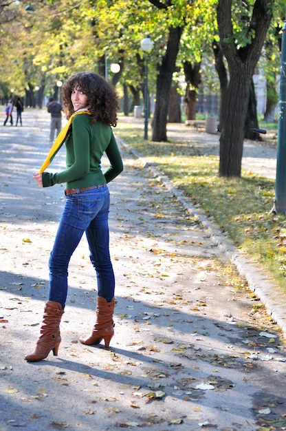 bruna Giovane donna carina con sciarpa colorata in posa all'aperto in natura