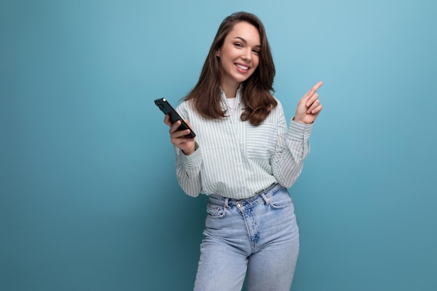 Bruna giovane donna in camicia in chat in smartphone su sfondo per studio con ritmo di copia