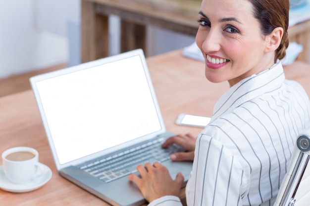 Bruna imprenditrice sorridendo con laptop