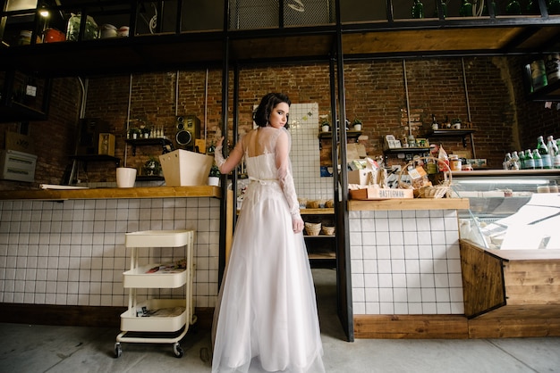 Bruna modello in capelli corti in posa in un abito da sposa bianco