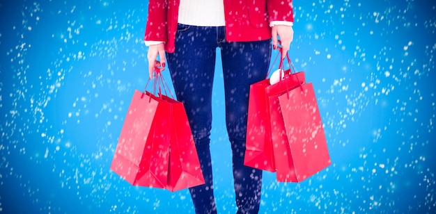 Bruna sorridente in abiti invernali che tengono le borse della spesa su sfondo blu con vignetta