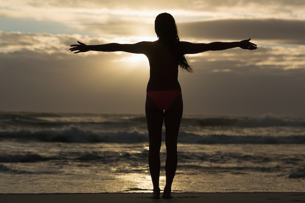 Bruna sportivo che si estende sulla spiaggia