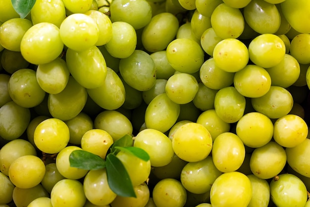 Brunch di frutta fresca Uva verde sullo scaffale nel mercato della frutta fresca Grappolo di uva succosa matura fresca verde come primo piano di sfondo