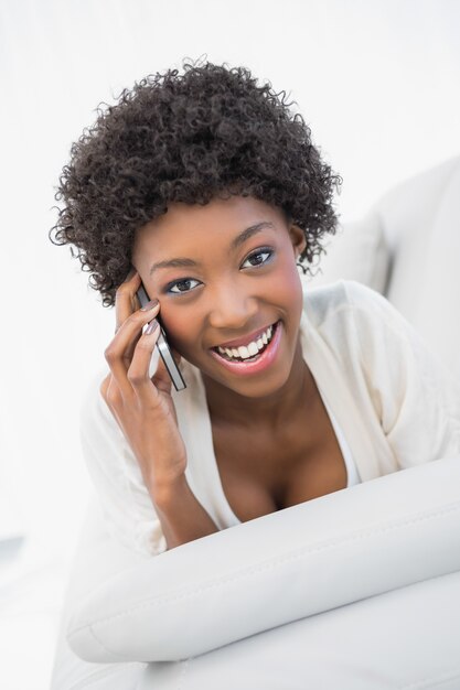 Brunette attraente sorridente che ha una telefonata