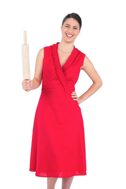 Brunette elegante sorridente in matterello rosso della holding del vestito