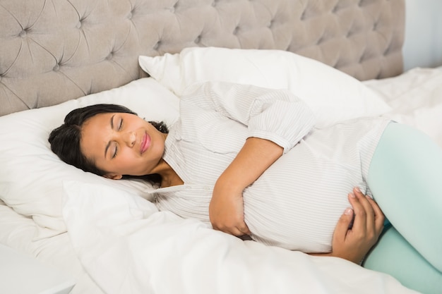 Brunette incinto che dorme sul letto