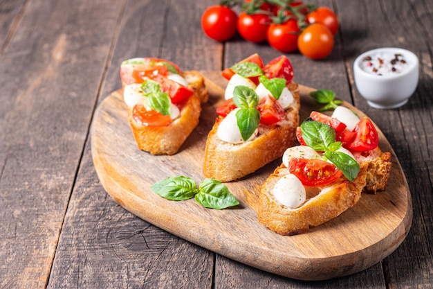 Bruschetta caprese fresca di pomodoro, basilico e formaggio. Tapas italiane, antipasti alle verdure, lui