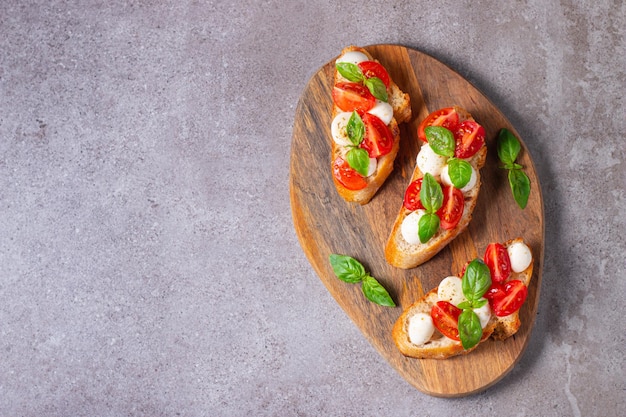 Bruschetta caprese fresca di pomodoro, basilico e formaggio. Tapas italiane, antipasti alle verdure, lui