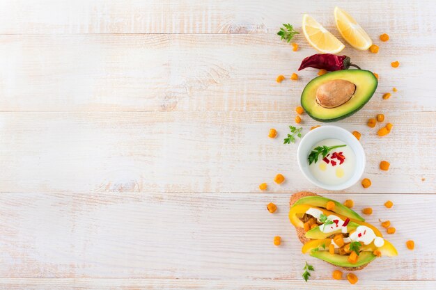 Bruschetta con avocado, peperone giallo, chicchi di mais, prezzemolo e peperoncino