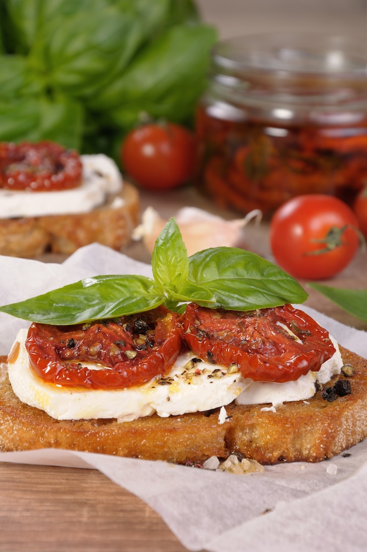 Foto bruschetta con feta e fettine di pomodori secchi speziati