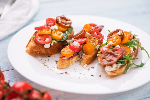 Bruschetta con formaggio, basilico, rucola e pomodorini