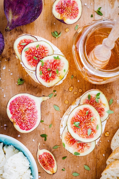 Bruschetta con formaggio di capra fichi freschi miele e timo su tavola di legno