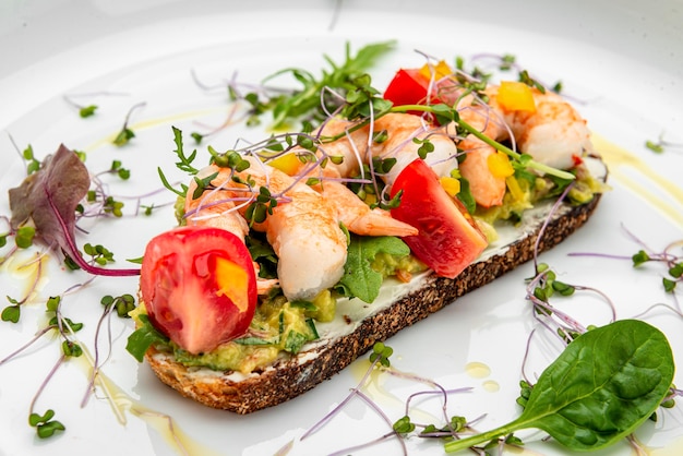 Bruschetta con gamberetti, pomodori e salsa di gluacomoli Servire il cibo in un ristorante Concetto di cibo sano