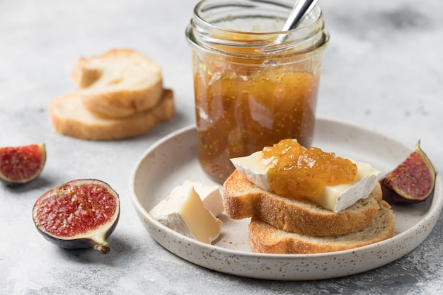 Bruschetta con marmellata di fichi e formaggio brie camembert su piatto in ceramica Cibo sano