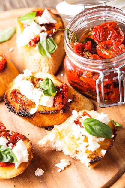 Bruschetta con olio d'oliva, pomodori secchi, feta e basilico fresco