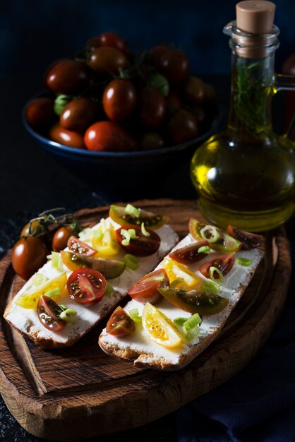 Bruschetta con pomodori e olio d'oliva su una tavola di legno - tradizionale spuntino italiano, spagnolo, fuoco selettivo