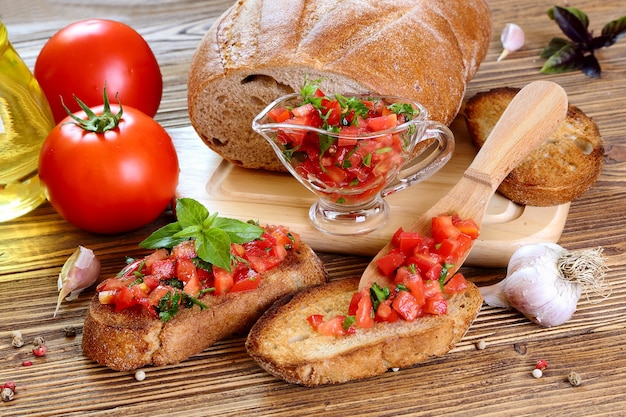 Bruschetta con pomodoro, aglio e basilico su un tavolo di legno