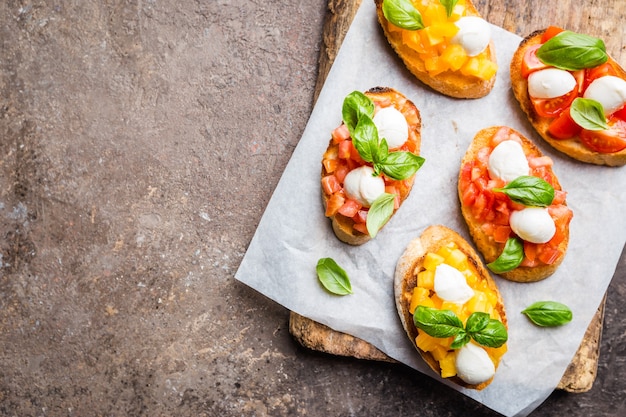 Bruschetta con pomodoro, basilico e mozzarella su tavola di legno