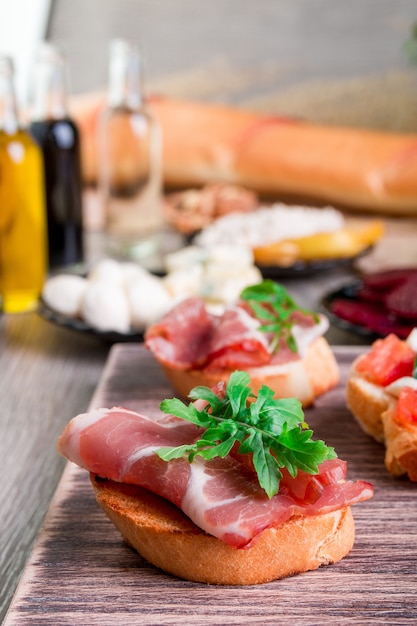 Bruschetta con prosciutto e rucola su legno.