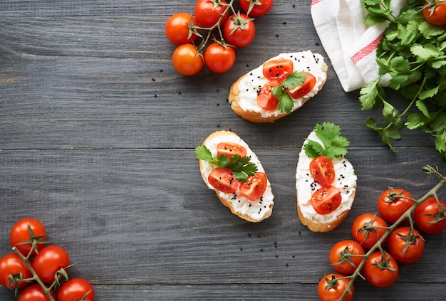 Bruschetta con ricotta, pomodorini e coriandolo su legno