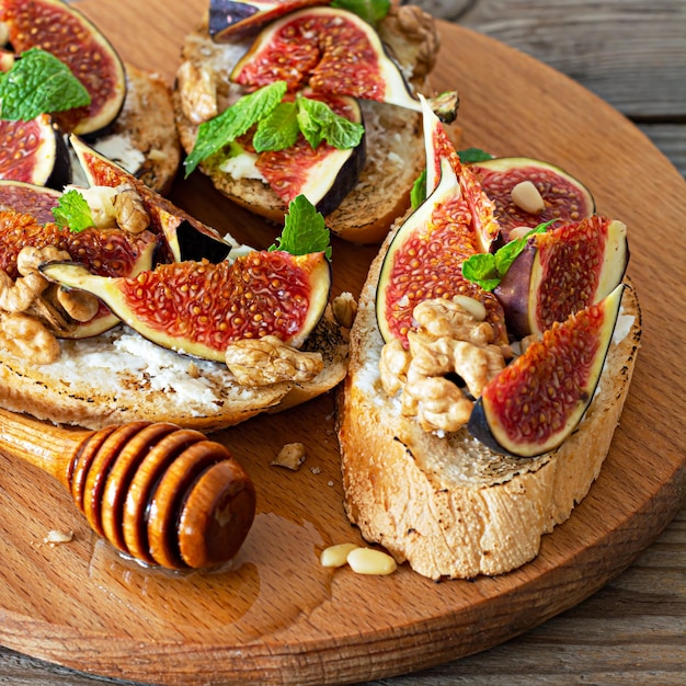 Bruschetta croccante con ricotta morbida, fichi maturi, noci e pinoli, menta e miele