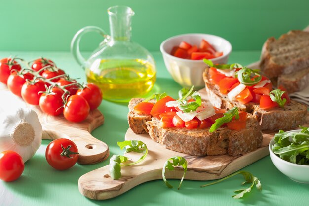 Bruschetta italiana con rucola di parmigiano di pomodori