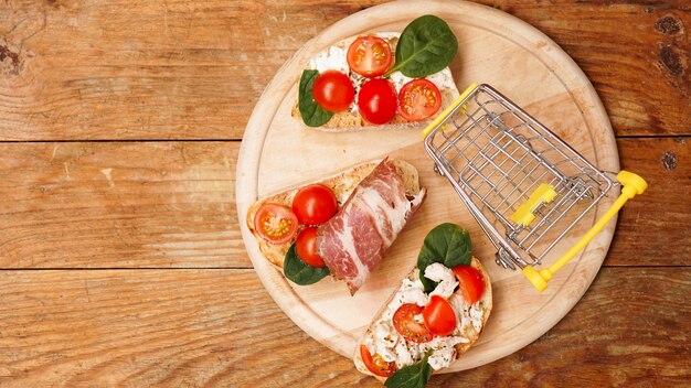 Bruschetta italiana su un acquisto di ingredienti del cestino del negozio della tavola di legno