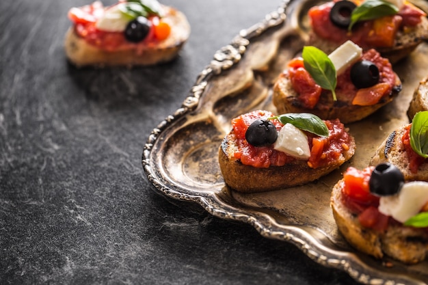 Bruschetta toast con mozzarella pomodori olive basilico e olio d'oliva Cucina italiana