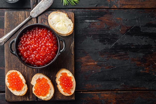 Bruschette con caviale rosso burro, sul vecchio tavolo in legno scuro