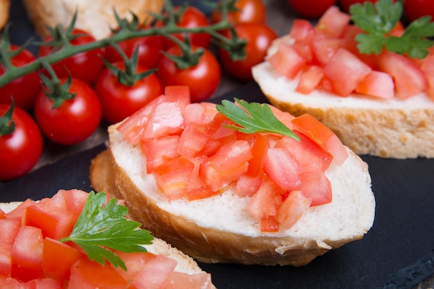 Bruschette italiane tradizionali con pomodorini sul piatto di pietra