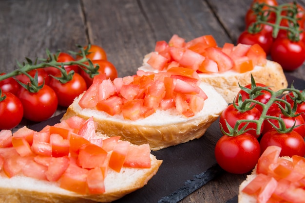 Bruschette italiane tradizionali con pomodorini sul piatto di pietra