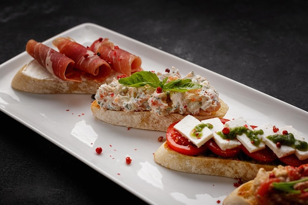 Bruschette varie con prosciutto, frutti di mare, verdure e formaggio