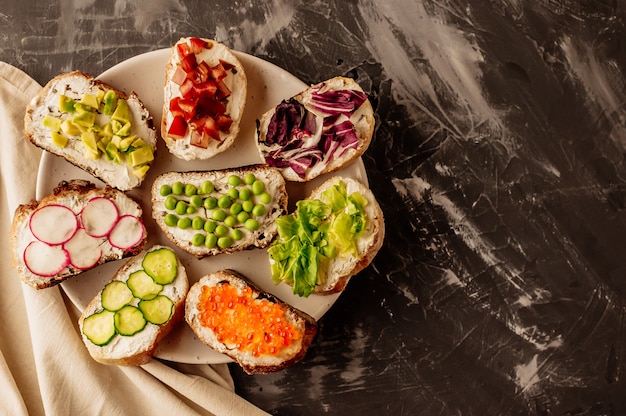 Brushetta o tapas spagnole tradizionali. Gli spuntini italiani degli antipasti hanno messo sul bordo di legno.