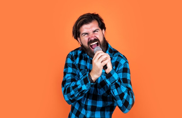 Brutale cantante rock uomo barbuto che canta una canzone nel microfono alla musica rock karaoke