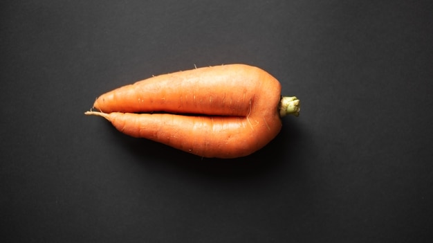 brutta carota su uno sfondo nero scuro vista dall'alto