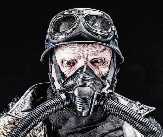 Brutta faccia del soldato nazista futuristico in maschera antigas e casco d'acciaio. Pelle bruciata dalla fiamma atomica