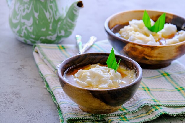 Bubur sumsum. Porridge dolce giavanese di farina di riso, latte di cocco con sciroppo di zucchero di palma. Servito in una ciotola di legno. Un popolare alimento iniziale per rompere il digiuno durante il Ramadan.