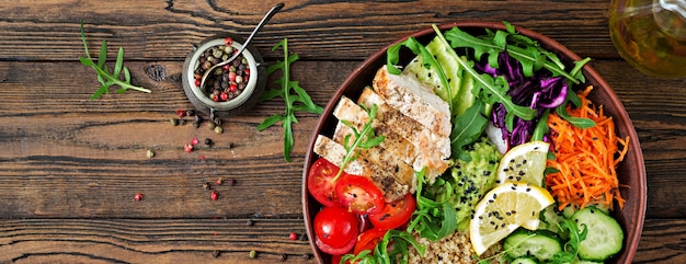 Buddha bowl lunch con pollo alla griglia e quinoa, pomodoro, guacamole e rucola. Top vie