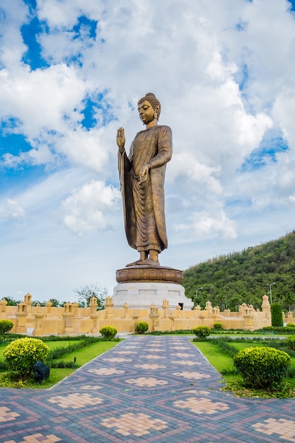 Buddha dorato gigante che sta scenico nel posto buddista