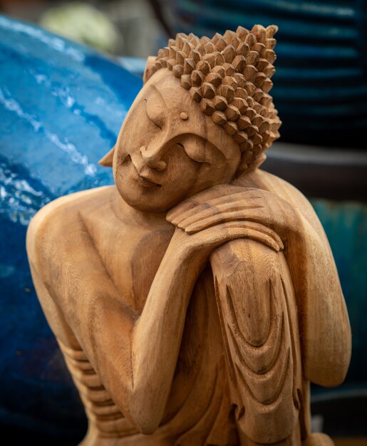 Buddha in legno con testa appoggiata sulle mani