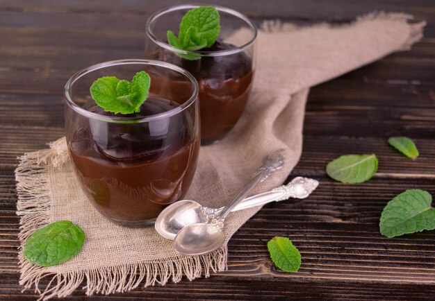 Budino al cioccolato in bicchieri su uno sfondo di legno