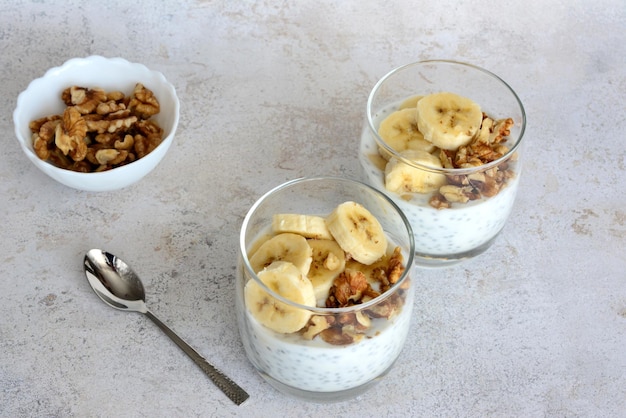 budino alla banana e chia con fette di noci e banana in bicchieri