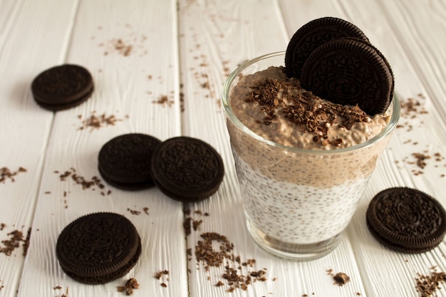 Budino con chia e biscotto al cioccolato sul tavolo di legno bianco