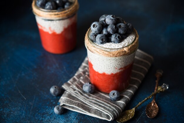 Budino di chia vegano con latte di cocco e purea di fragole in un barattolo