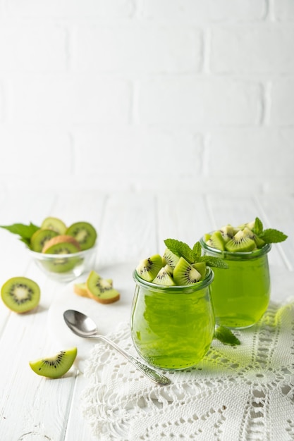 Budino di gelatina dolce dessert con kiwi in vaso di vetro su sfondo bianco