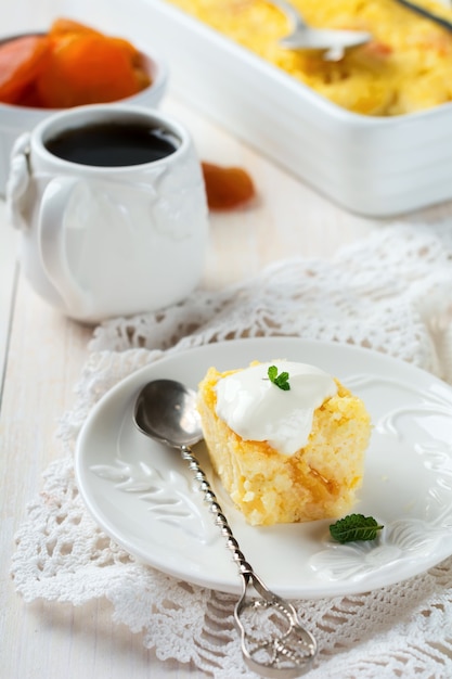 Budino di miglio con albicocche secche per colazione su sfondo chiaro. Messa a fuoco selettiva.